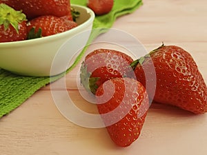 Fresh strawberry dish towel on a pink wooden background