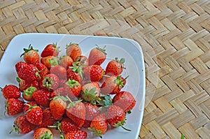 Fresh strawberry dish on woven bamboo floor