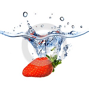 Fresh strawberry dropped into blue water