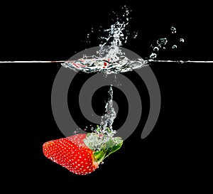 Fresh strawberry dropping into water
