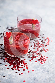 Fresh strawberry margarita or daiquiri cocktail with hearts over gray background, valentine day concepts