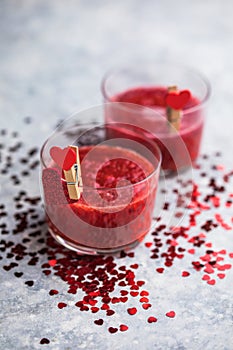 Fresh strawberry margarita or daiquiri cocktail with hearts over gray background, valentine day concepts