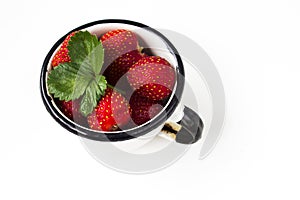 Fresh strawberry in a mug on white background
