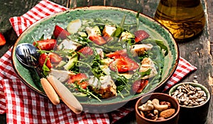 Fresh strawberry salad with arugula, chicken, avocado and strawberries. Plate with a keto diet food. Top view, Food recipe