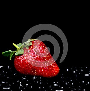 Fresh strawberry with water drops on black