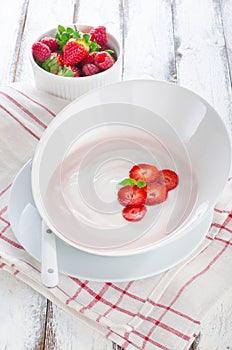 Fresh strawberry yoghurt in a bowl with fresh berries