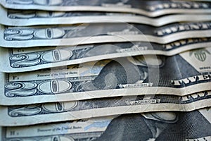 Fresh, stylish 20 US dollar bills laid out in an interesting and beautiful way on a wooden background.