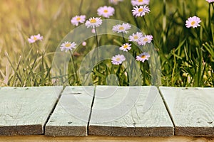 Fresh summer flowers, grass and sunlight, and wooden flooring.