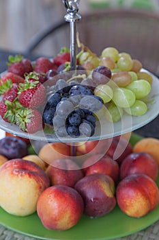 Fresh summer fruits. Organic and natural fruit on tray. Fresh grapes, cheaches, plums and strawberry. Healthy eating.