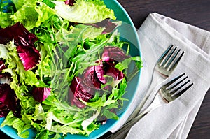 Fresh summer green salad mix on a wooden table