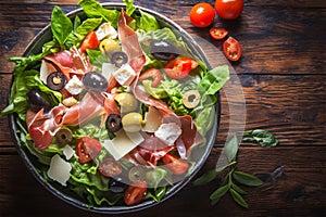 Fresh summer medley Lettuce, olives, tomatoes, parmesan, and prosciutto salad