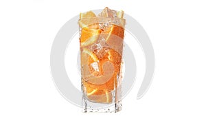 Fresh summer rotation glass cocktail with orange piece ice and bubbles mineral water slowmo isolated