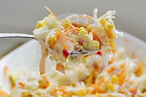 Fresh summer salad with with crab sticks, corn and carrots in bowl on table. Concept of healthy eating