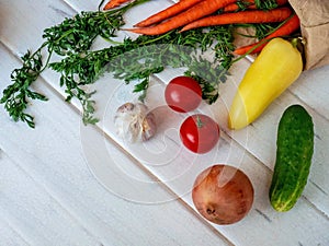 Fresh summer vegetables on a white wooden background.