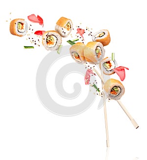 Fresh sushi rolls with ginger frozen in the air, isolated on white background