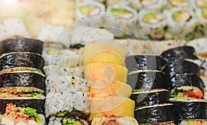 Fresh sushi rolls with salmon, avocado, tuna and cucumber. Maki plate with rice and nori. Delicious Japanese food with sushi roll