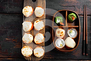 Fresh Sushi rolls with wasabi and ginger, on old dark  wooden table background, top view flat lay