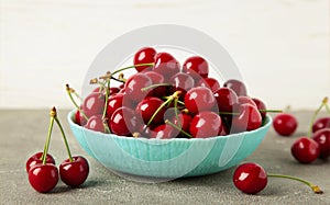 Fresh sweet cherries bowl on grey background, top view