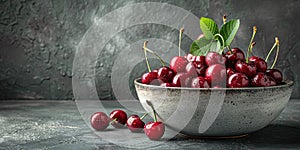 Fresh sweet cherries bowl with leaves in water drops on blue stone background, top view