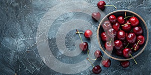 Fresh sweet cherries bowl with leaves in water drops on blue stone background, top view