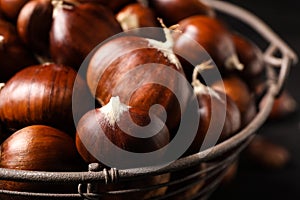 Fresh sweet edible chestnuts in basket, closeup