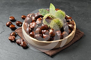 Fresh sweet edible chestnuts on black slate table
