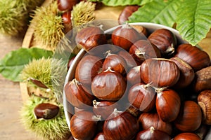 Fresh sweet edible chestnuts in bowl on table, top view