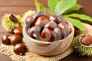 Fresh sweet edible chestnuts on brown table, closeup