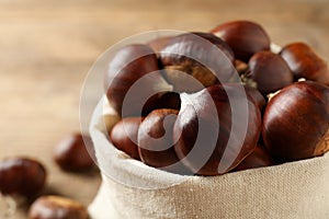 Fresh sweet edible chestnuts in sack, closeup