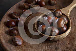 Fresh sweet edible chestnuts in wooden bowl, closeup