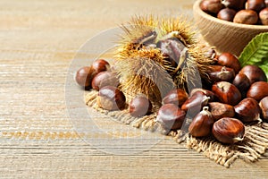 Fresh sweet edible chestnuts on wooden table