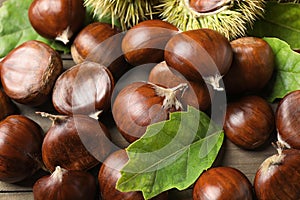 Fresh sweet edible chestnuts on wooden table, closeup