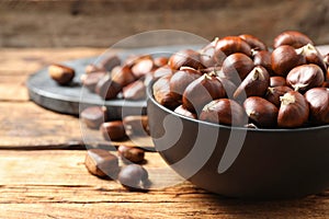Fresh sweet edible chestnuts on wooden table, closeup