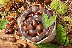 Fresh sweet edible chestnuts on wooden table, flat lay