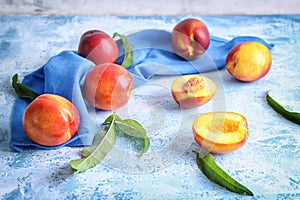 Fresh sweet peaches with napkin on color table