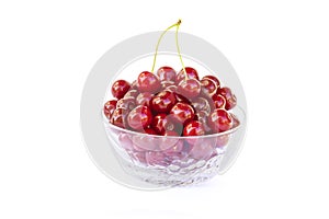 Fresh sweet red cherries in a glass bowl, ripe and juicy cherry fruit, healthy food, close-up, isolated on a white