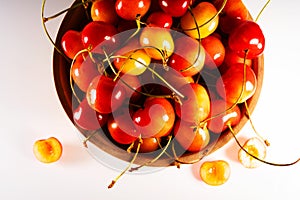 Fresh sweet ripe cherries in a wooden bowl isolated on a white background.