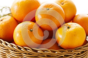 Fresh tangerine orange fruits in wooden basket