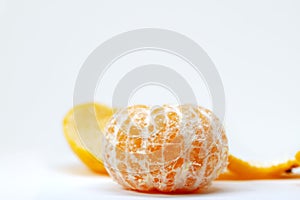 Fresh tangerine peeled off on white background. Orange citrus fruit studio photo. Whole tangerine without peel