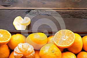 Fresh tangerines in brown box on wooden background with green fir branches. Frame, copy space, holiday and winter fragrance, new