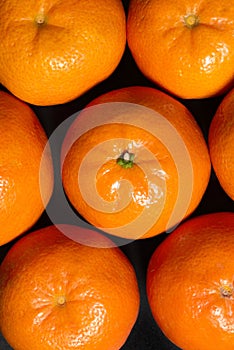 Fresh tangerines, fruit as a background on a black background, top view