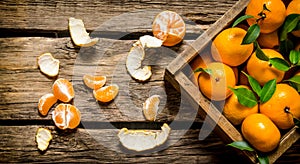 Fresh tangerines in an old box with leaves.