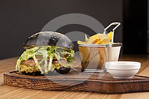 Fresh tasty burger and french fries on wooden table