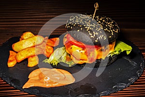 Fresh tasty burger and french fries on wooden table