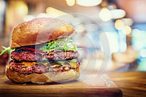 Fresh tasty burger on wooden table. Hamburger fast food restaurants background.