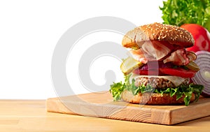 Fresh tasty burger on a wooden table isolated on white background