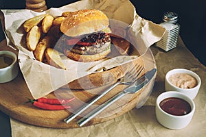 Fresh tasty burgers with french fries and sauce on the wooden table top