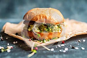 Fresh tasty burgers with roasted chicken, potato, micro greens and different herbs on the rustic background