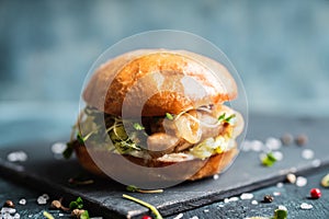 Fresh tasty burgers with roasted chicken, potato, micro greens and different herbs on the rustic background