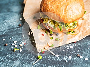 Fresh tasty burgers with roasted chicken, potato, micro greens and different herbs on the rustic background